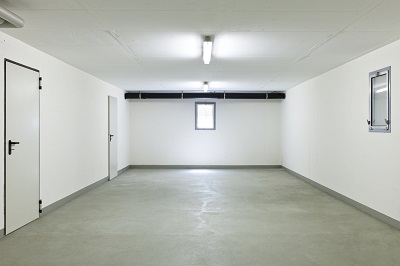 Basement floor with white walls and two doors.