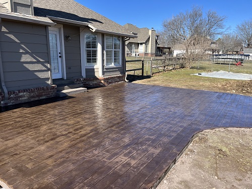 Back patio that has a decorative lay on the top making it look like wood planks.