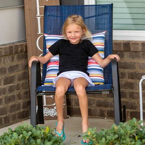 Young girl sitting in a chair smiling