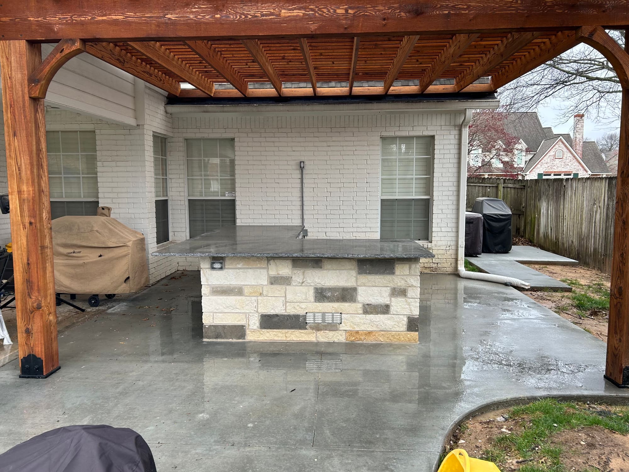 Concrete patio with large grill and pergola