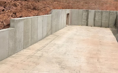 Retaining wall with dirt coming up the back side of it. 