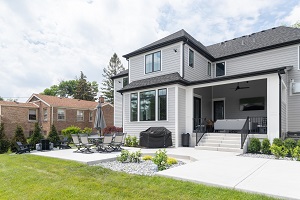 Large white house with a large back porch area showing step and lots of area made of concrete