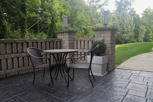 Stamped concrete on a patio with chairs and a table.