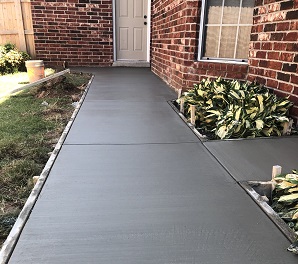 Fresh concrete walkway going up to a house door